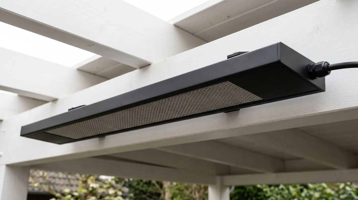 Radiateur infrarouge extra-plat noir mat installé sous plafond de pergola blanche, design discret et finition aluminium