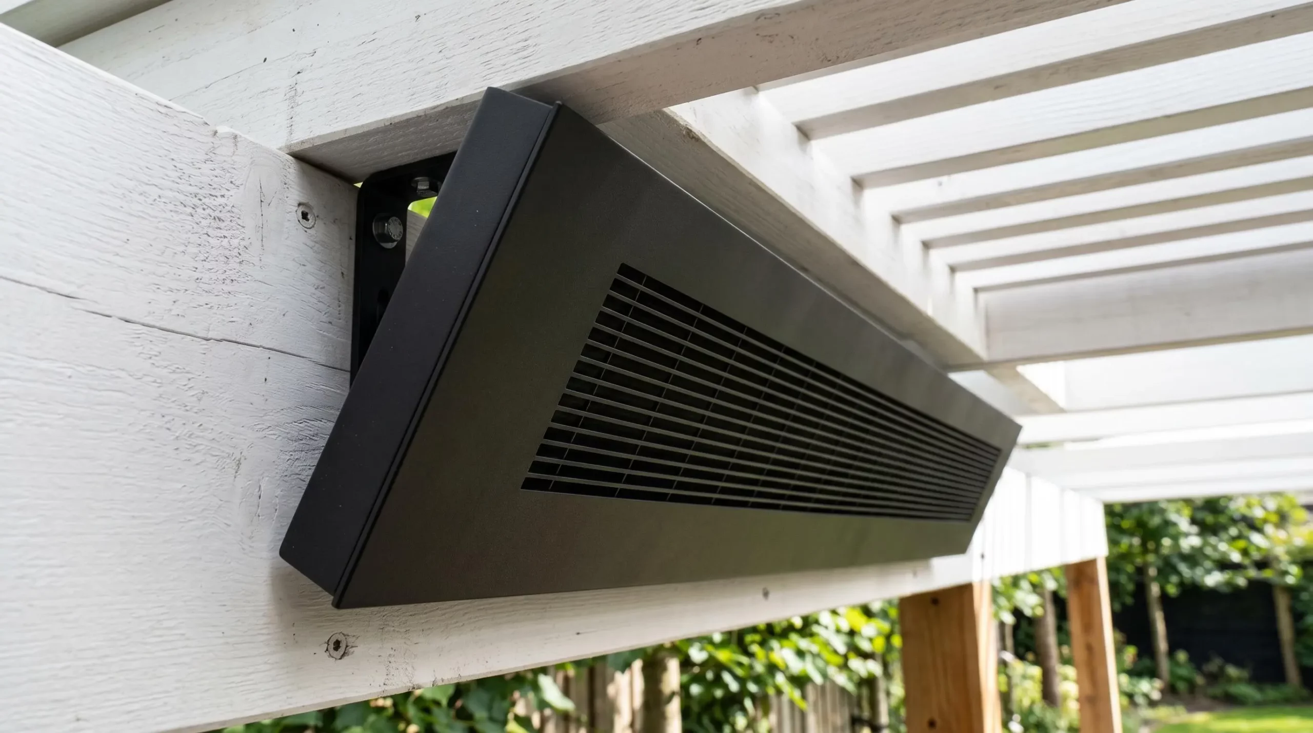 Radiateur infrarouge extra-plat noir mat installé sous plafond de pergola blanche, design discret et finition aluminium